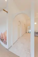 아치와 팜파스가 어우러진 화이트톤 카페 인테리어